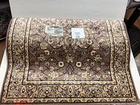 Rolled-up view of Sultan Mashed carpet runner showing patterned surface in dusty rose and beige colors.