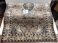 Top side view of a beige, dusty rose, black and cream colored carpet runner with intricate traditional design and floral borders.