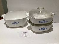 3 white CorningWare dishes with blue cornflower pattern; 2 lids seen stacked
