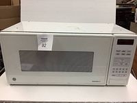 White GE Spacemaker II microwave oven front view showing door and control panel with numeric and preset buttons.