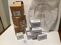 Lot overview showing boxes of Moen fixtures including body sprays and the toilet seat in plastic wrapping