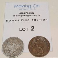 Photo showing reverse sides of the 1915 US half dollar with heraldic eagle and the 1917 Great Britain penny featuring seated Britannia.