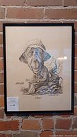 Framed caricature artwork showing full view with signature and brick wall background