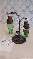 Photo showing the fish-shaped salt and pepper shakers suspended on the metal stand, capturing the detailed textures and overall lot presentation.