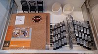 Photo showing 8-pack of cork tiles, 20 chrome skirt hangers, and two white Flip and Tumble storage suction hooks in packaging.