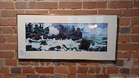 Framed acrylic painting titled "Stormy Weather" depicting a stormy ocean landscape with waves, trees, and rocks, hanging on brick wall.