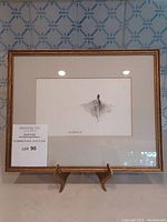 Overall view of framed ink sketch by Paul Fournier on stand
