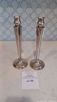 Front view of pair of sterling silver candlestick holders on countertop