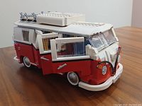 Front and side view of red and white Lego Volkswagen T1 Camper Van with doors open