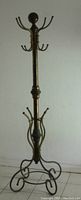 Full view of the brass clothes tree showing all hooks and base.