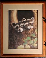 Full view of the framed painting showing two raccoon babies peeking from a tree hole with a wood frame.