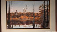 Front view of the framed print showing the sunset or evening flight scene in a wetland with flying birds and surrounding trees.
