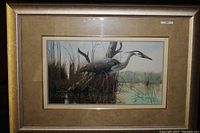 Framed signed and numbered print titled "Stalking The Shallows" showing a heron in a marsh near shallow water, matted and framed.