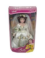 Front view of boxed Belle porcelain doll in wedding dress with veil and bouquet, visible through clear plastic window of pink Disney Princess box.