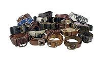 Multiple designer belts in various styles, colors, and buckle types piled together