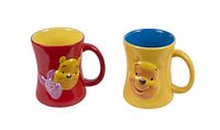 Two Disney store 3D character mugs featuring Winnie the Pooh and Piglet, one red with yellow interior, one yellow with blue interior.