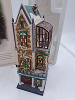 Front and partial side view showing detailed façade with wreaths, windows, double door entrance and snow-covered roof with chimney