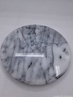 Top view of polished round marble lazy Susan showing grey and white veining pattern.