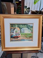 Front view of framed oil painting showing coastal scene with boats and houses