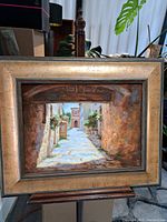 Frontal view of framed painting on wooden easel