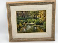 Framed oil painting showing the entire marshland scene with trees, bushes, and water reflections.