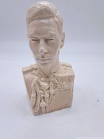 Front view of the cream-colored ceramic bust of King George VI showing facial features and detailed uniform.