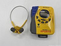 Overview of yellow Sony Sports Walkman and matching earbuds on white background