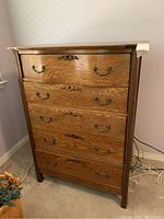 Front view of oak dresser showing five drawers and carved detailing