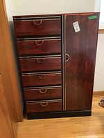 Front view of wood cabinet with six drawers and a door featuring semi-circular handles.