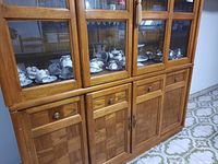 Wide shot of wooden cabinet filled with various espresso set items and dinnerware, showing storage and quantity of the lot