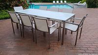 Full view of rectangular patio dining table with eight chairs arranged around
