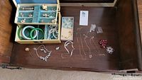 Overview of open jewelry box and table with assorted jewelry pieces