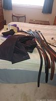 Belts, snow pants, slippers, and belts laid out on bed