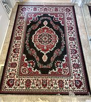 Full view of the carpet showing the entire ornate patterned area rug with fringe.
