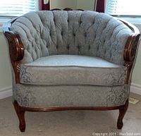 Front view of curved-back chair showing tufted back and seat cushion