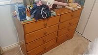 Full front view of the wood dresser showing all drawers and items on top (contents not included).