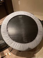 Top down image showing round trampoline with black jumping surface and grey padded edge.