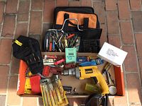 Lot contents arranged in boxes: DeWalt drill, various drill and driver bits, bit holders, black fabric drill holster, bit sharpener, hammer, and sealed box of drill oil.