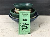 Stacked view of the six artisan pottery bowls showing size and color variation with a Maxsold lot tag.