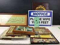 Photo showing framed vintage map (wood frame) on the left, framed matchbook cover collection in center, vintage style metal notice sign behind items, and other assorted framed prints and small framed matchbook collections.