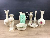 Eight Lenox porcelain pieces including pitcher, vases, bowl, and candy dish arranged together on a table