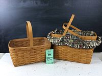 Two Longaberger hand woven rectangular baskets side by side, one with floral fabric liner and the other without liner, placed on white surface against black background