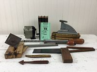 Photo showing various vintage tools including wooden folding rules, metal stapler, pencil sharpener, scraper, small square, and ratchet screwdrivers.