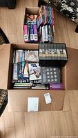 Full view of the open box showing an assortment of DVD box sets and individual DVDs arranged inside.