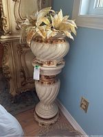 Full view of gold faux flowers in faux marble pot and stand showing overall height and details