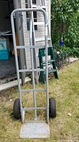 Front view of the metal hand cart dolly showing tubular frame, handle, load plate and two pneumatic wheels.
