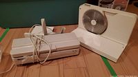 Photo showing the Deco Sonic food sealer, a white rectangular device with cord.