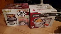 Photo showing the boxed Parini dual compartment slow cooker with capacity and product image.