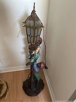 Full standing lamp with two child figurines climbing a central pole with lantern lamp at the top