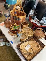 Overview of all baskets on white table showing various sizes and styles including large basket with star design and other smaller baskets.
